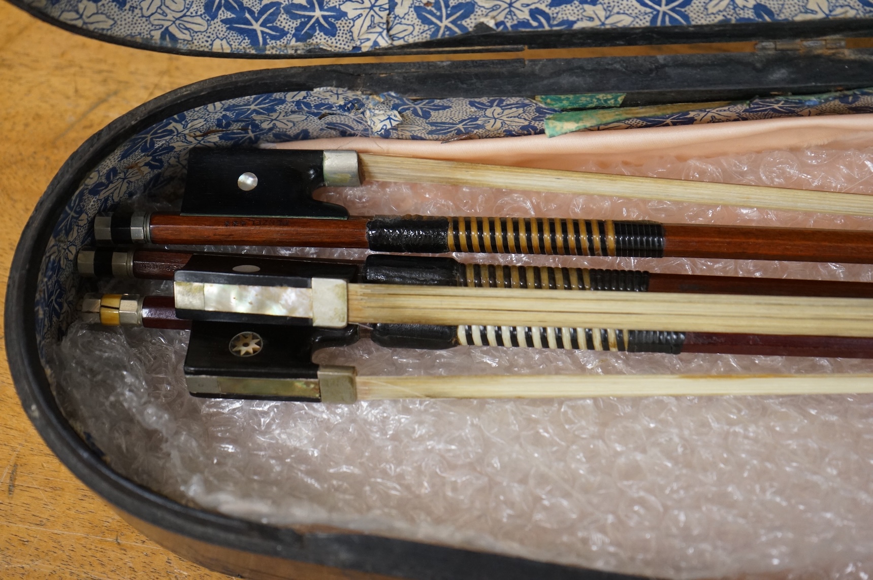 Three German violin bows; an octagonal stick stamped Penzal, together with another stamped E.L. Herrmann and a further unsigned example, all octagonal sticks and fully mounted with nickel mounts, together with an early 2